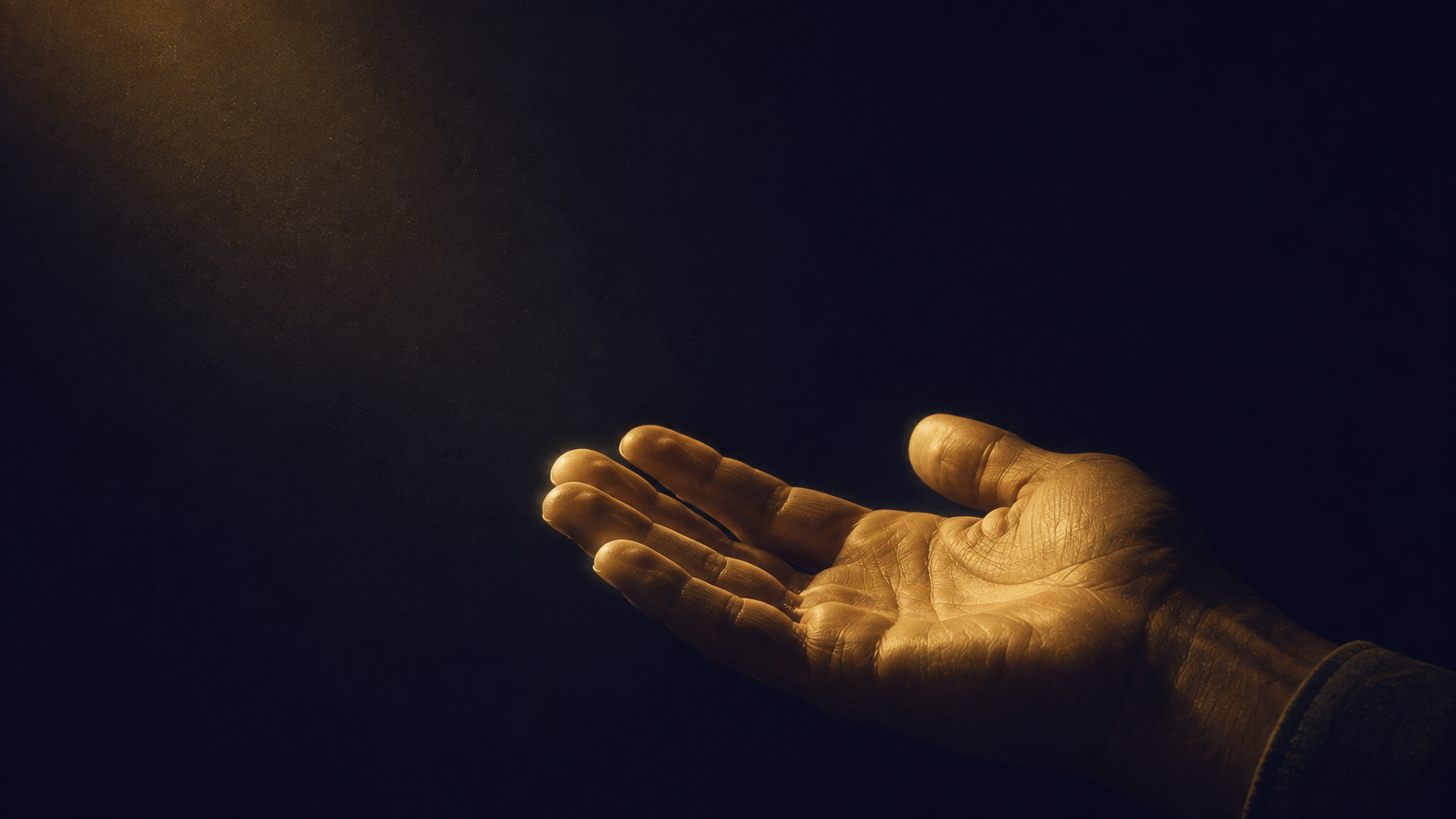 An open hand extended palm up into warm light against a dark background